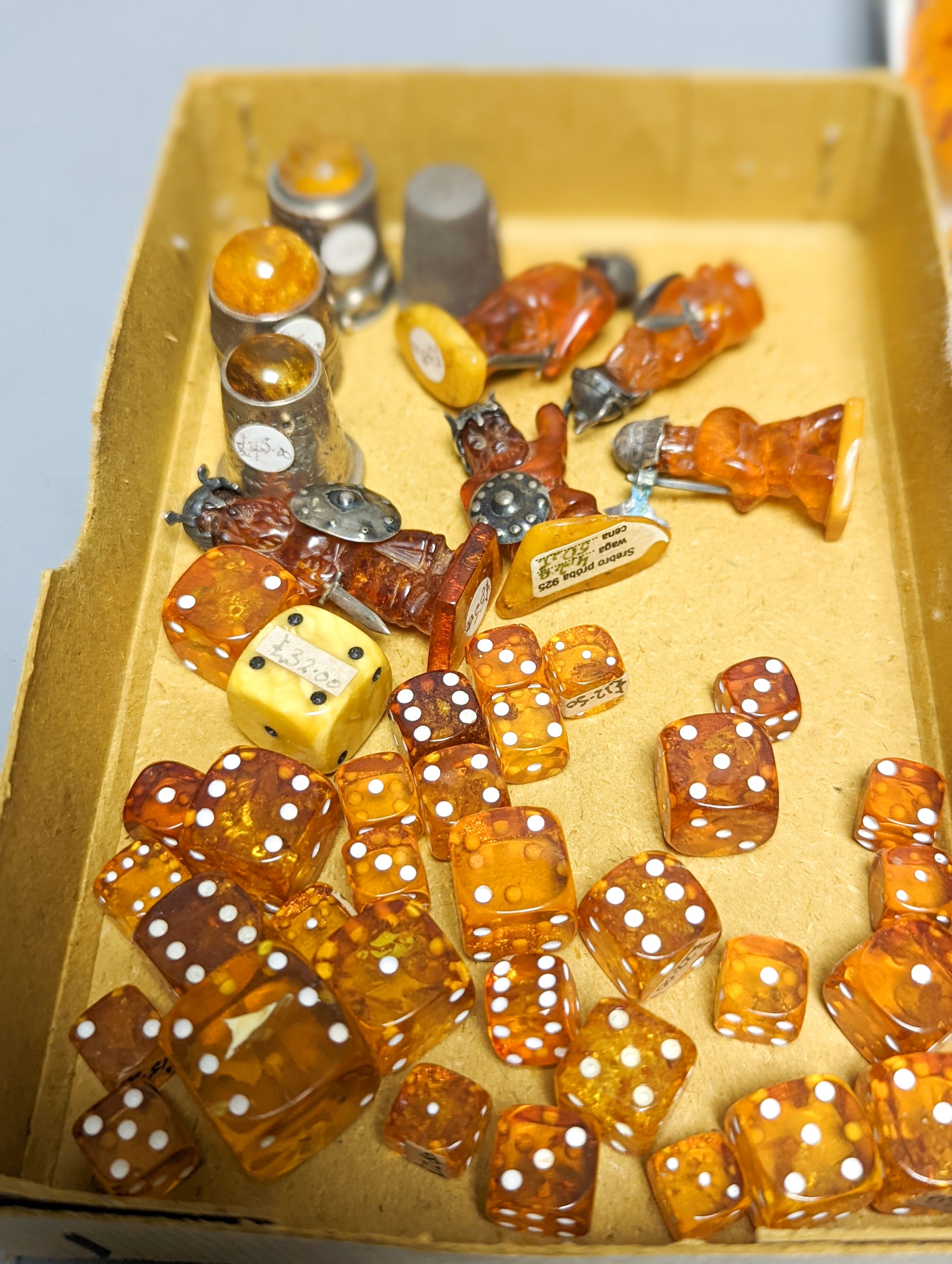 A mixed collection small carved amber wares including dice, eggs and cigarette holders, etc.